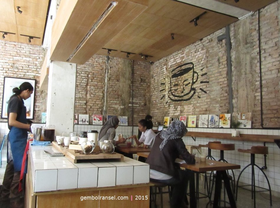 Dinding bata merah dan material kayu mendominasi interior kedai